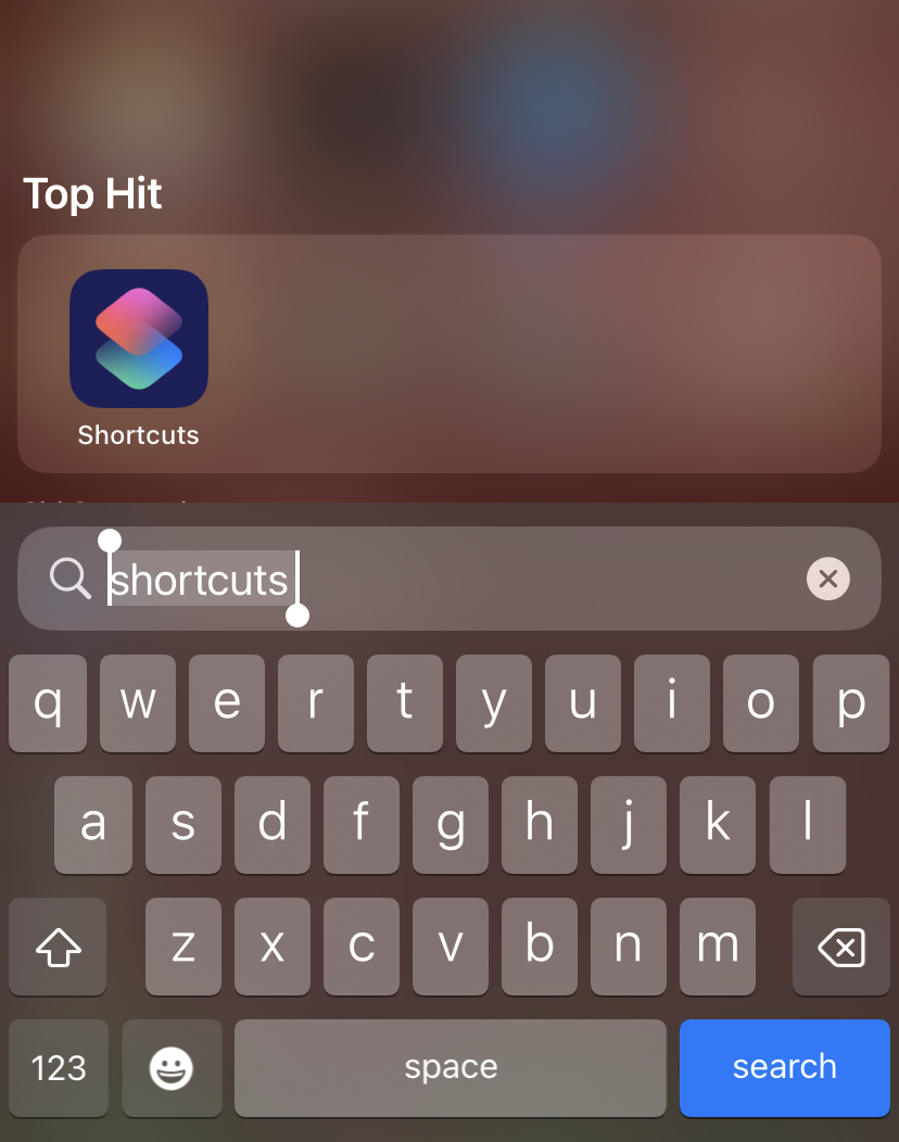 This image is of the search bar on an iPhone where 'shortcuts' has been typed and the 'shortcuts' button is above under 'Top Hit.'