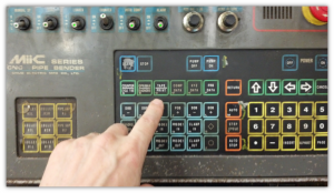 A finger pressing a button on a machineDescription automatically generated